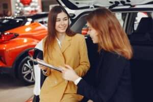 friendly car dealer showing the contract to a customer